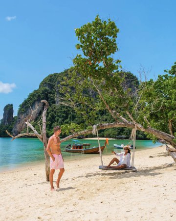 Junge asiatische Frauen und europäische Männer am Strand während eines Urlaubs in Thailand. ein vielseitiges Paar auf einem tropischen Ferieninsel-Hopping in Thailand, Koh Phakbia Island liegt in der Nähe von Koh Hong Krabi in Thailand 