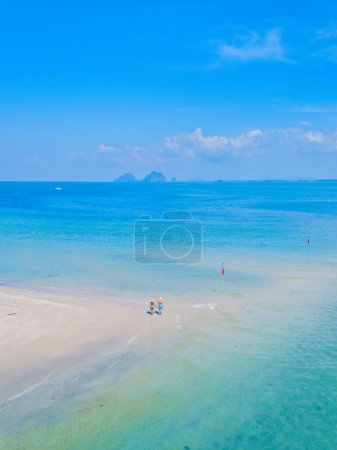 ein paar Männer und Frauen am Strand während eines tropischen Urlaubs in Thailand, Koh Muk eine tropische Sandbank in einem blauen Ozean mit weichem weißen Sand und einem türkisfarbenen Meer Koh Mook Thailand