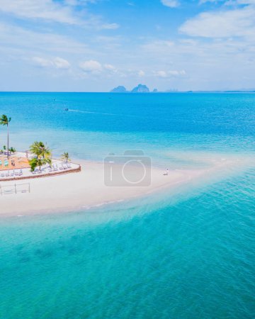 Drone top view at Koh Muk tropical island turqouse colored ocean Koh Mook Trang Thailand, a couple on a sandbar in the ocean on a sunny day, top vertical view