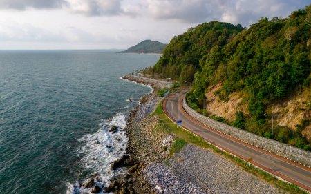 car driving on the curved road of Thailand. road landscape in summer. it's nice to drive on the beachside highway. Chantaburi Province Thailand, summer road trip alongside the ocean