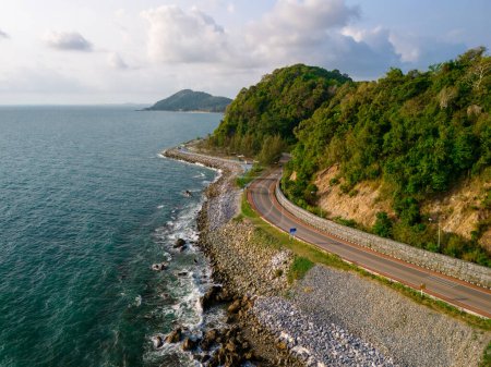 Téléchargez les photos : Voiture conduisant sur la route courbe le long de la route de plage de l'océan de Thaïlande. paysage routier en été. C'est agréable de rouler sur la route en bord de mer. Province de Chantaburi Thaïlande, drone vue aérienne - en image libre de droit