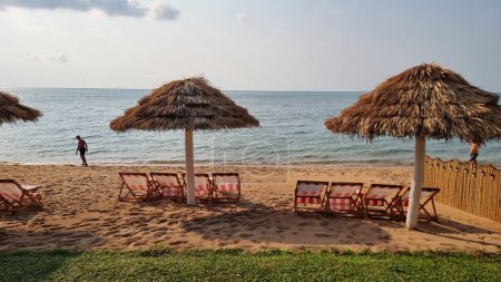 Photo for Bangsaray Pattaya Thailand 28 February 2024, Chairs and umbrellas adorn a tranquil beach near the ocean, inviting relaxation and enjoyment of the scenic coastal views. - Royalty Free Image