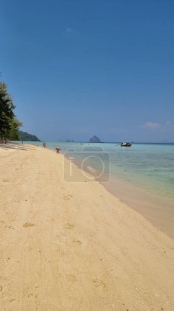 Foto de Una playa de arena serena donde un barco solitario flota suavemente en las aguas tranquilas, rodeado de la belleza de la naturaleza. Koh Kradan Tailandia - Imagen libre de derechos
