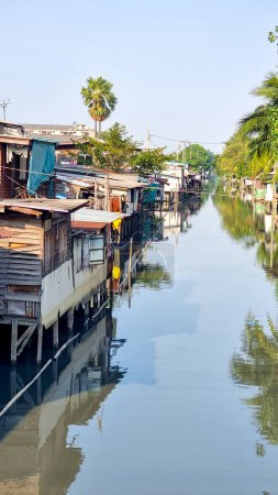 Foto de Bangkok Tailandia 13 enero 2024,, Sereno cuerpo de agua con casas encantadoras flotando en su superficie, creando una pintoresca escena de arreglos de vida únicos. - Imagen libre de derechos