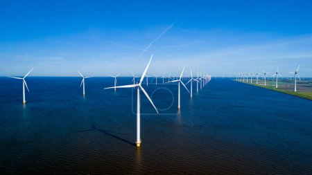 Foto de Una impresionante escena de innumerables molinos de viento de pie en un vasto cuerpo de agua, creando una fascinante muestra de energía renovable en acción. turbinas de molinos de viento en el océano - Imagen libre de derechos