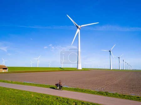 Foto de Una pintoresca escena de un parque eólico en Flevoland, Países Bajos, con múltiples molinos de viento que giran con la brisa primaveral. turbinas de molino de viento, energía verde, ecológico, día de la tierra - Imagen libre de derechos