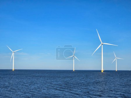 Photo for Windmill park in the ocean, Energy transition, zero emissions, carbon neutral, Earth day concept, windmills isolated at sea in the Netherlands. - Royalty Free Image