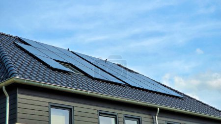 Photo for Newly built houses with black solar panels on the roof, Close up of new family home with black solar panels. Zonnepanelen, Zonne energie, Translation: Solar panel, Sun Energy - Royalty Free Image