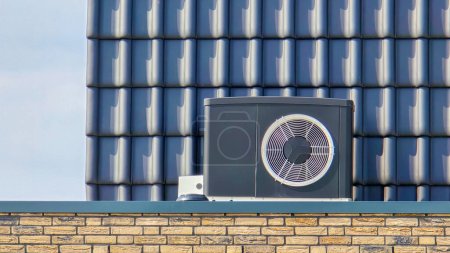 Luftquelle Wärmepumpe im Freien an einem modernen Haus mit Ziegeln in den Niederlanden im Frühjahr installiert, warme Pomp Translation Luftquelle Wärmepumpe, Luftquelle Wärmepumpe auf dem Dach