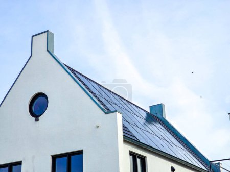 Téléchargez les photos : Maisons familiales modernes nouvellement construites avec des panneaux solaires noirs sur le toit, Gros plan du nouveau bâtiment avec des panneaux solaires noirs. Zonnepanelen, Zonne energie, Traduction : Panneau solaire, Énergie solaire - en image libre de droit