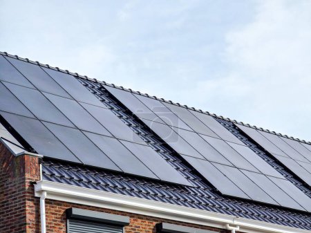 Téléchargez les photos : Maisons nouvellement construites avec des panneaux solaires noirs sur le toit, Gros plan de la nouvelle maison familiale avec des panneaux solaires noirs. Zonnepanelen, Zonne energie, Traduction : Panneau solaire, Énergie solaire - en image libre de droit