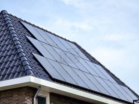 Téléchargez les photos : Maisons nouvellement construites avec des panneaux solaires noirs sur le toit, Gros plan de la nouvelle maison moderne avec des panneaux solaires noirs. Zonnepanelen, Zonne energie, Traduction : Panneau solaire, Énergie solaire - en image libre de droit