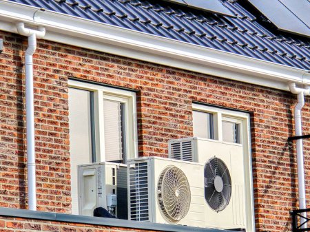 Foto de Air source heat pump unit installed outdoors at a modern home with solar panels in the Netherlands, Zonnepanelen, Warmte pomp, Translation: Solar panel, Air source Heat pump - Imagen libre de derechos