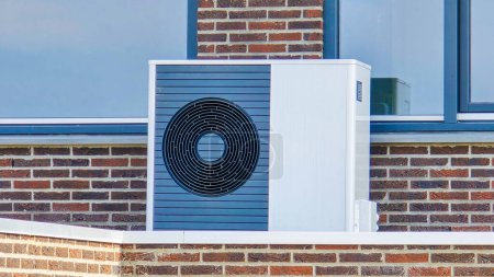 unité de pompe à chaleur de source d'air installée à l'extérieur dans une maison moderne aux Pays-Bas au printemps, pompe à chaleur de source d'air de traduction de pompe à chaleur, transition énergétique du gaz naturel à la source électrique