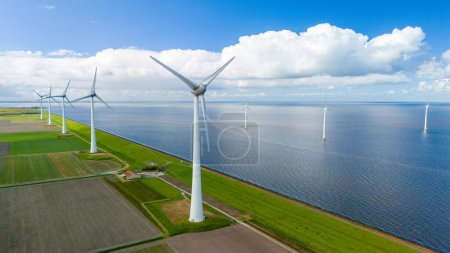 Foto de Las turbinas eólicas giran con gracia en un parque eólico ubicado cerca del océano, aprovechando la energía de la brisa para generar energía renovable. en el Noordoostpolder Países Bajos - Imagen libre de derechos