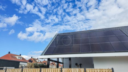 Téléchargez les photos : Une maison moderne avec un panneau solaire élégant sur son toit, exploitant les énergies renouvelables pour alimenter la maison et réduire l'empreinte carbone aux Pays-Bas - en image libre de droit