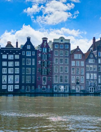 Téléchargez les photos : Une scène pittoresque d'une rangée majestueuse de bâtiments debout à côté d'un plan d'eau tranquille, créant un mélange harmonieux d'architecture et de nature. Amsterdam Pays-Bas 21 avril 2024 - en image libre de droit