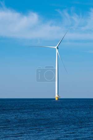 Foto de Una turbina eólica solitaria se alza en el vasto océano, aprovechando el poder del viento para generar energía limpia para un futuro sostenible. Turbinas eólicas en el mar, transición energética verde en Europa - Imagen libre de derechos