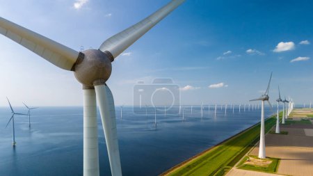 Foto de Vista aérea de las turbinas de molino de viento girando con gracia en un parque eólico cerca del océano en los Países Bajos Flevoland. - Imagen libre de derechos