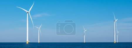 Téléchargez les photos : Une vue fascinante d'une rangée d'éoliennes tournant gracieusement dans le vaste océan, capturant la puissance des énergies renouvelables. éoliennes en mer, transition énergétique verte en Europe - en image libre de droit