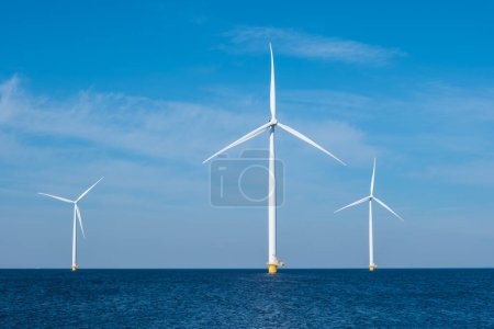 Vor der Küste von Flevoland in den Niederlanden erheben sich majestätisch Windturbinen aus dem Meer und nutzen die Kraft des Windes, um erneuerbare Energien zu erzeugen. Windkraftanlagen auf See mit blauem Himmel