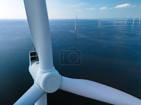 Photo for A lone wind turbine gracefully spins in the vast expanse of the ocean, harnessing the power of the wind in the Netherlands Flevoland. close up of windmill turbine - Royalty Free Image