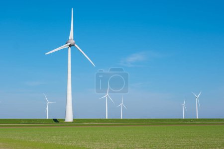 Dans le paysage pittoresque du Flevoland, les éoliennes tournent gracieusement dans le champ vert, exploitant les énergies renouvelables à chaque brise douce..