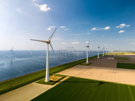 Photo for Serene wind farm in Flevoland, the Netherlands. Rows of majestic windmills gracefully turning in harmony, harnessing the power of the wind to generate renewable energy. - Royalty Free Image