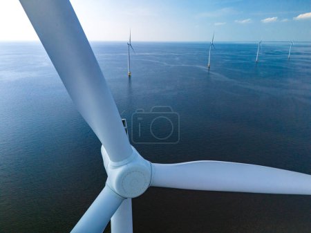 Foto de Una sola turbina eólica se alza en medio del vasto océano, aprovechando el poder del viento para generar energía renovable. primer plano de la turbina de molino de viento en el mar en los Países Bajos - Imagen libre de derechos