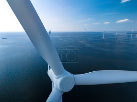 Foto de Una vista aérea impresionante de un parque eólico en el océano, mostrando filas de imponentes turbinas de molinos de viento que generan energía renovable en los Países Bajos Flevoland. - Imagen libre de derechos