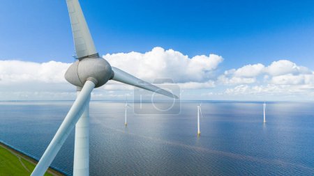 Foto de Una vista fascinante de las turbinas eólicas que giran graciosamente en el océano, aprovechando el poder del viento para generar energía limpia. - Imagen libre de derechos