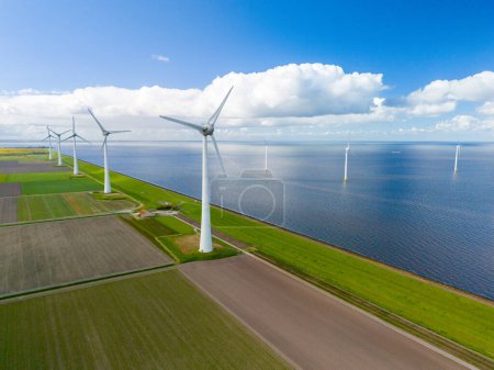 Téléchargez les photos : Une vue aérienne fascinante d'un parc éolien près de l'océan, où des rangées d'élégantes éoliennes captent la brise, exploitant l'énergie propre. - en image libre de droit