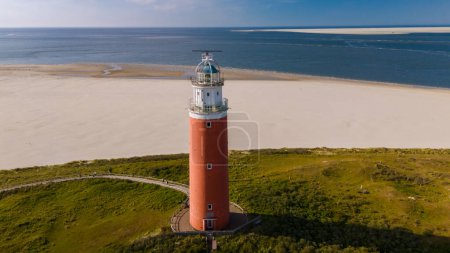 Majestätischer Leuchtturm ragt an Texels Sandstränden empor und bietet vorbeifahrenden Schiffen Sicherheit und Orientierung.