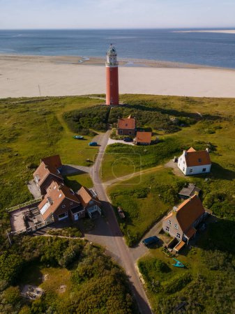 A majestic lighthouse stands tall near the sandy shores of Texel, overlooking the vast expanse of the sea with its bright beacon shining.
