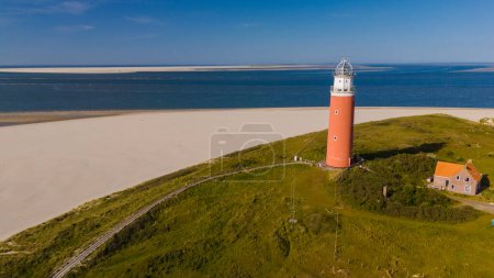 A solitary lighthouse stands tall on the sandy shores of Texel, guiding ships with its beacon of light and adding a touch of enchantment to the coastal landscape.