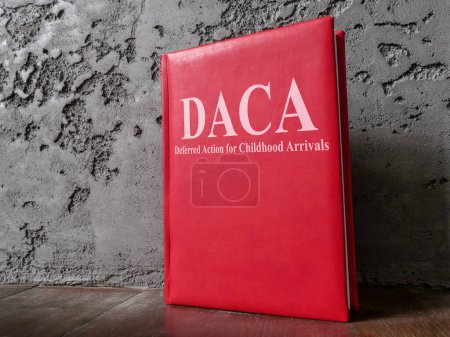 Foto de Libro Acción Diferida para los Llegados en la Infancia DACA ley cerca de la pared. - Imagen libre de derechos