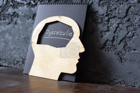 Photo for Handwritten word dyscalculia and a wooden head shape. - Royalty Free Image