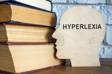 Photo for A Wooden head with word hyperlexia and books. - Royalty Free Image