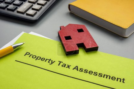 Documentos de evaluación del impuesto a la propiedad y un modelo de casa.