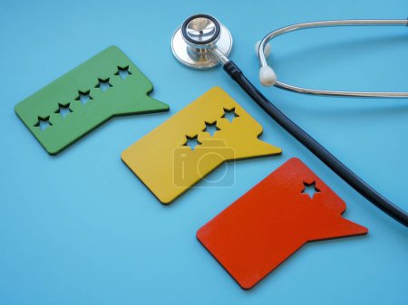 Téléchargez les photos : Un stéthoscope et des plaques avec des étoiles comme symbole de l'évaluation de l'expérience du patient. - en image libre de droit