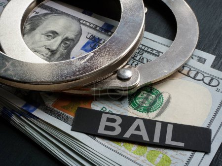 Handcuffs lie on cash and next to it is inscription bail.