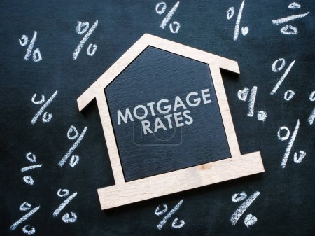 Téléchargez les photos : L'inscription sur les taux hypothécaires du modèle de maison et les signes en pourcentage. - en image libre de droit
