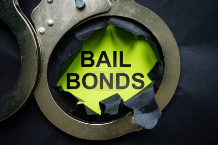 Photo for Bail bonds inscription and metal handcuffs. - Royalty Free Image