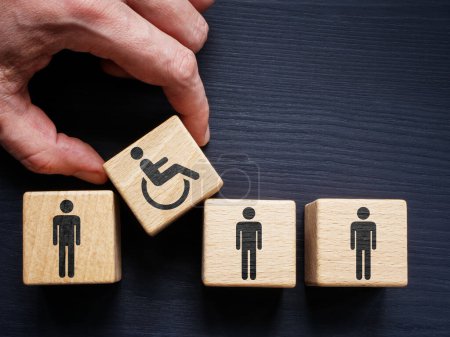Concepto de empleo e inclusión apoyado. Cubos con los empleados y la celebración de la mano con signo de persona discapacitada.