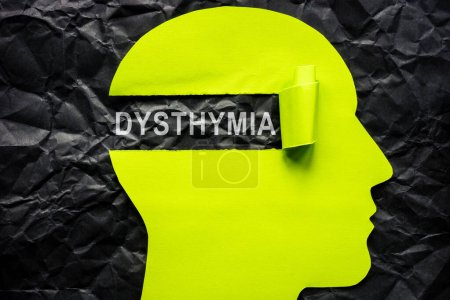 Paper head on crumpled surface and the word dysthymia.