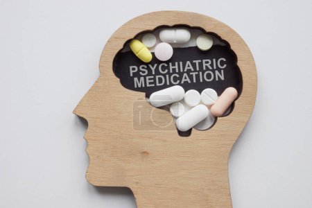 Modell des Kopfes mit Pillen und einer Inschrift psychiatrische Medikation.