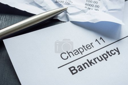 Foto de Capítulo 11 bancarrota y documentos arrugados con estado financiero. - Imagen libre de derechos