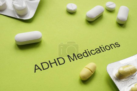 Green sheet of paper with inscription ADHD medications and pills.
