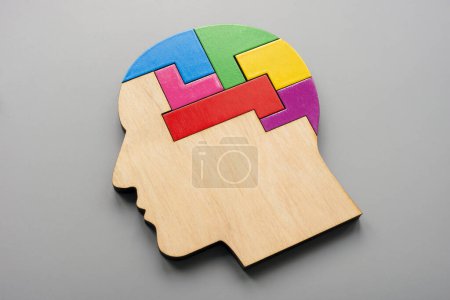 Wooden head made from colored puzzle pieces. Autism, neurodiversity or creativity concept.
