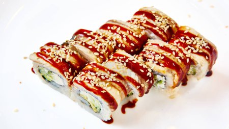 Foto de Rollos de sushi Unagi. Sushi con anguila, queso crema y aguacate, espolvoreado con semillas de sésamo blanco y negro. - Imagen libre de derechos